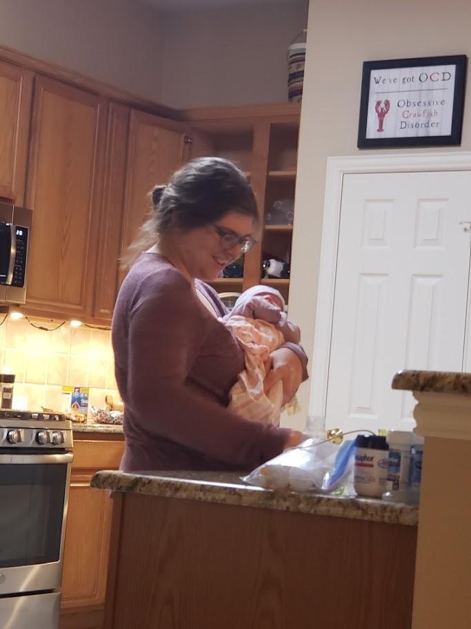 A woman holding a baby in a kitchen