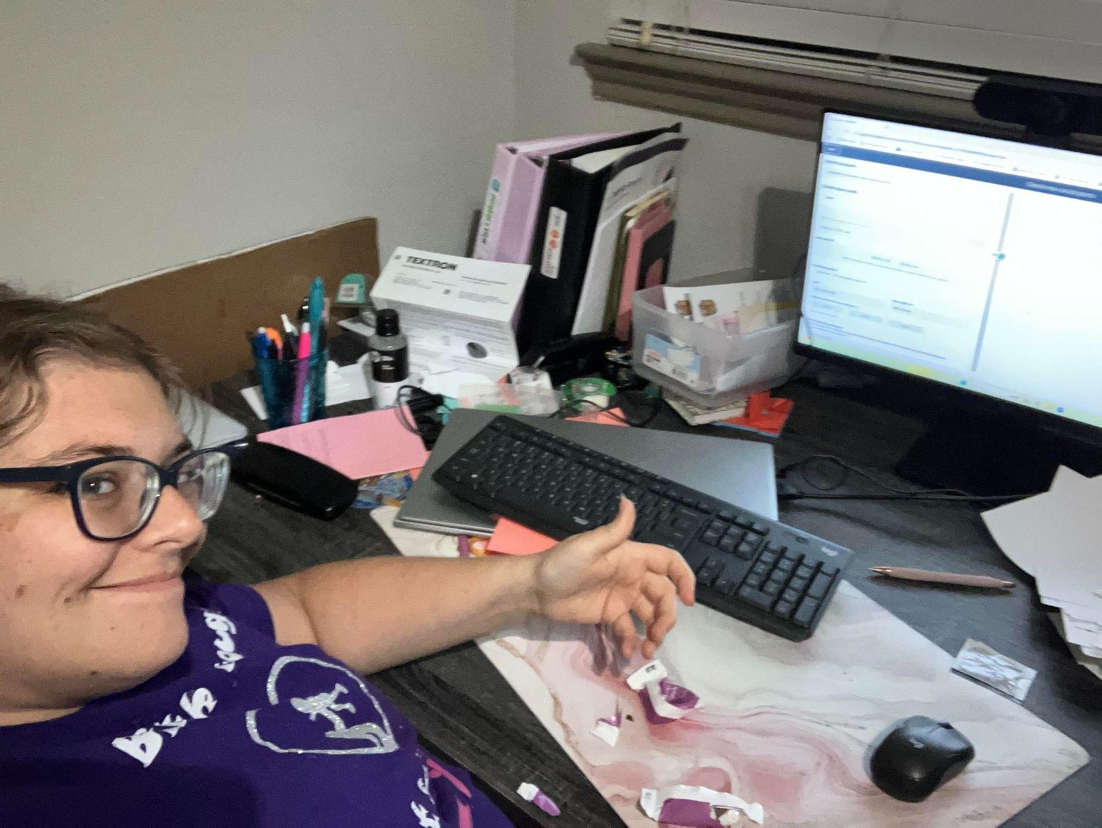 Melanie sitting at a desk with a computer and office supplies