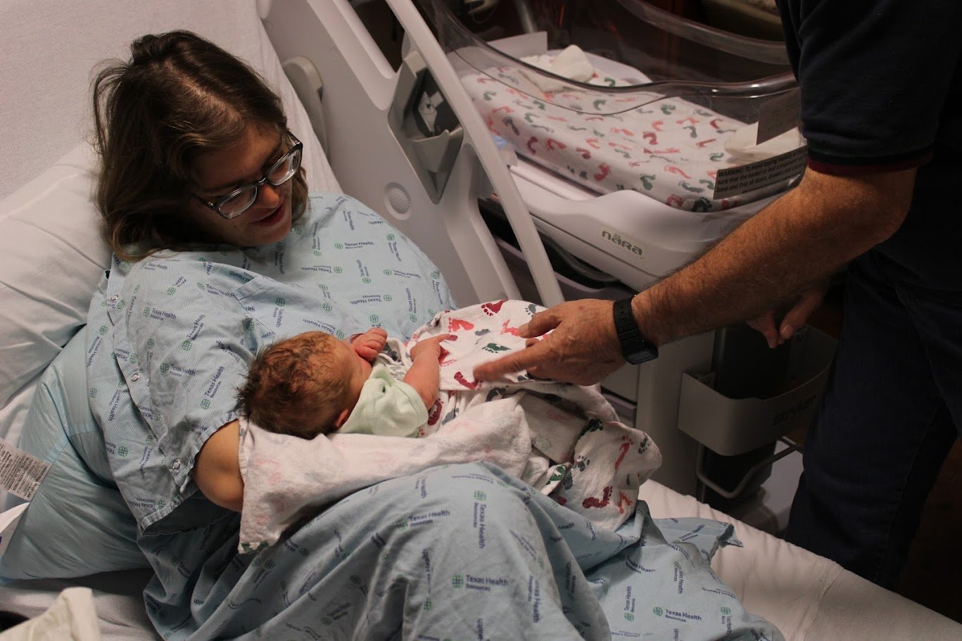 Doula Melanie Powell holding her newborn baby looking lovingly in her eyes 
