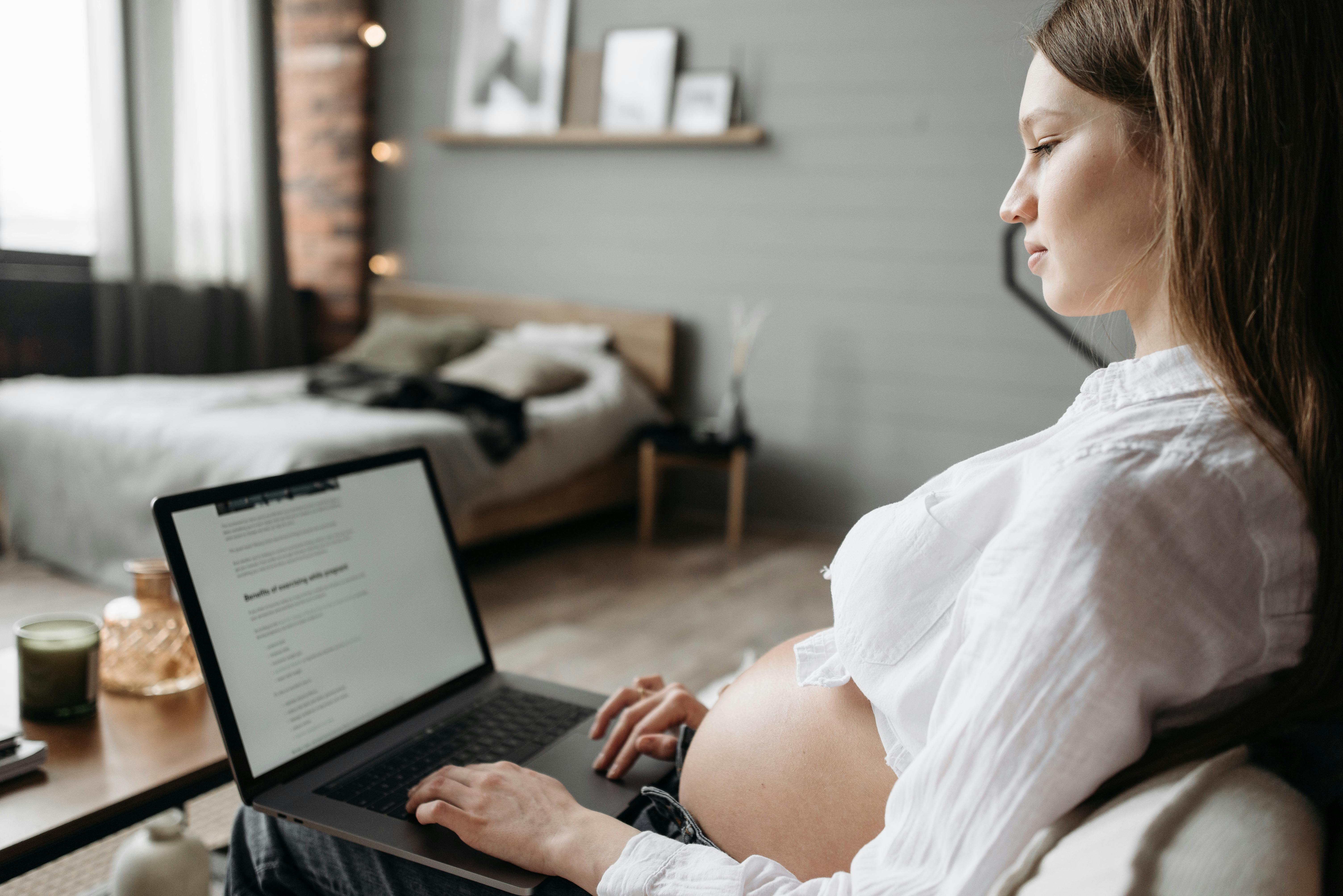 a pregnant woman on her laptop in a comforting and serene atmosphere 